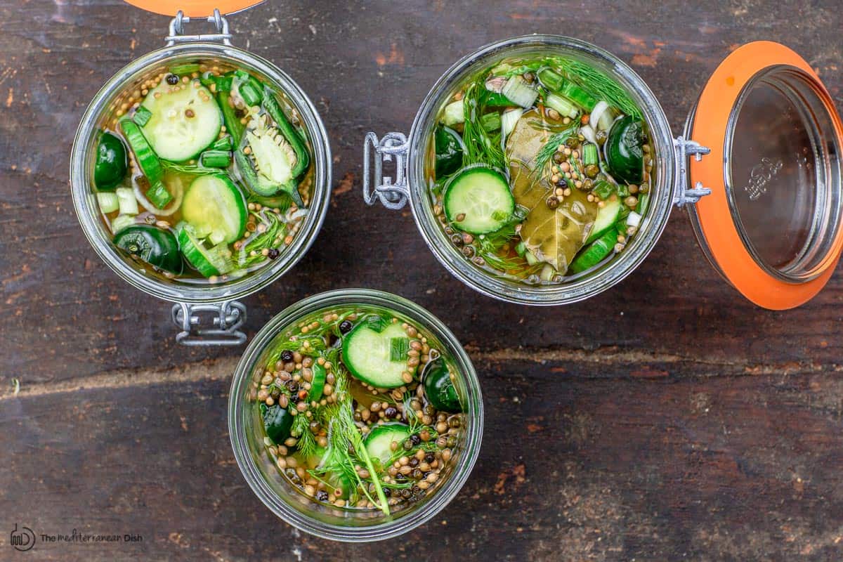 three open jars of pickled cucumbers