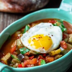 Ratatouille served in a blue pan topped with an egg