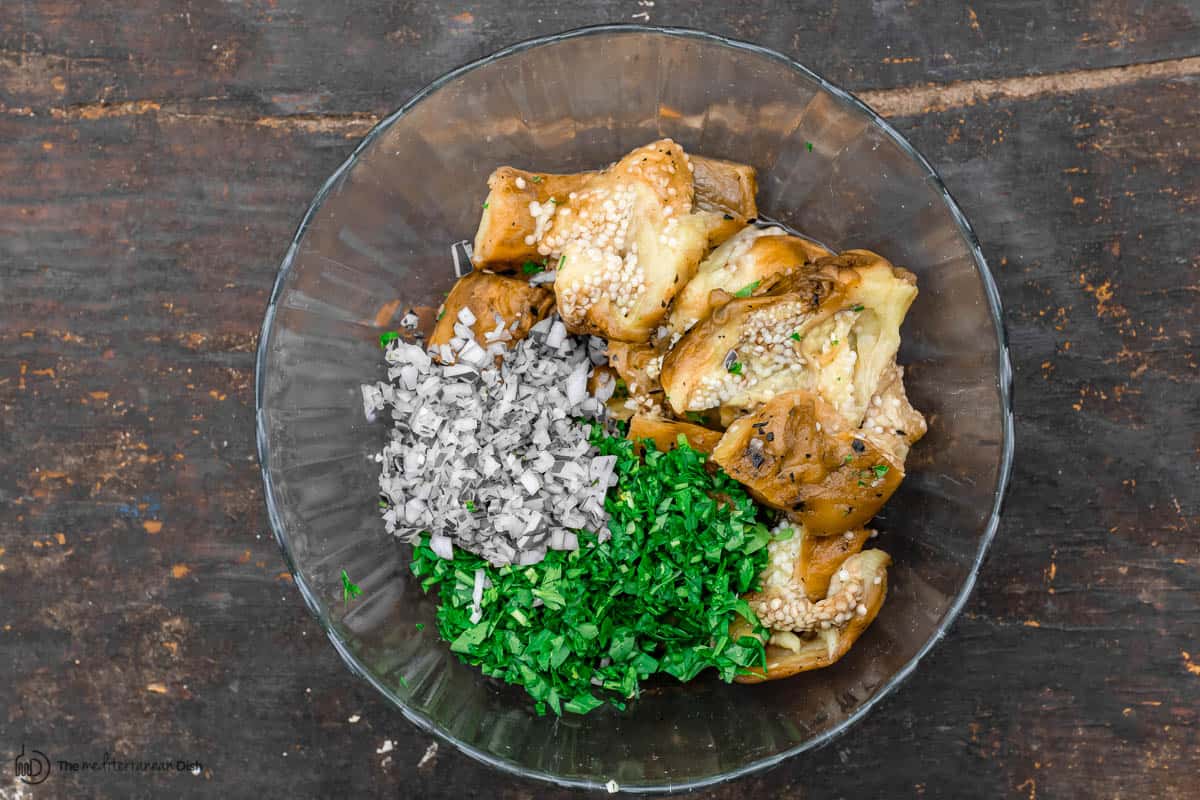 eggplant, fresh parsley, garlic, and onion in a mixing bowl for eggplant dip