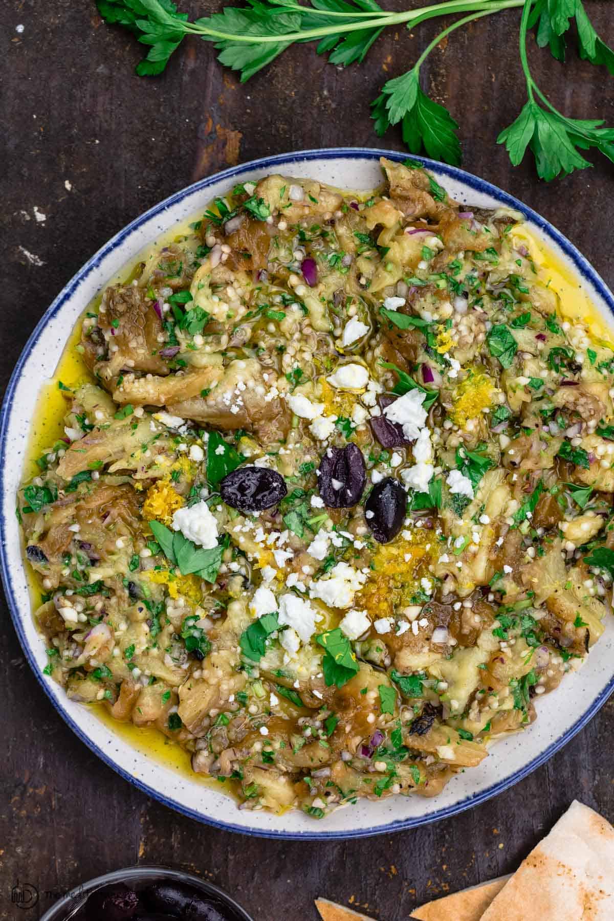 melitzanosalata (Greek eggplant dip) garnished with parsley, feta and olives