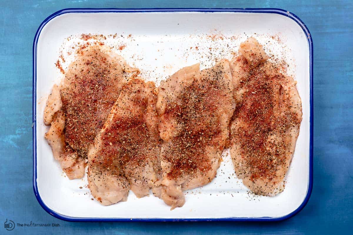Seasoned chicken pieces on a tray