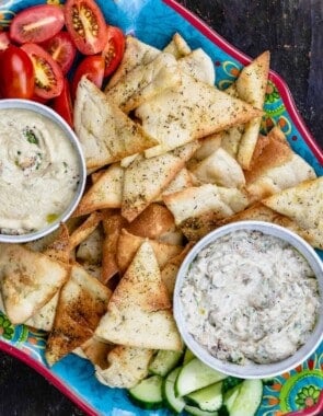 Homemade pita chips as part of mezze platter with two dips and veggies