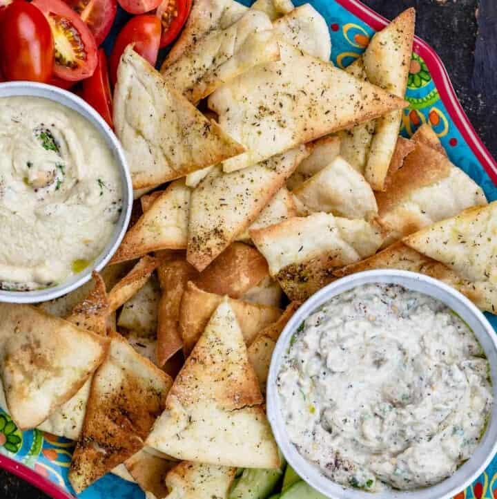 Homemade pita chips as part of mezze platter with two dips and veggies