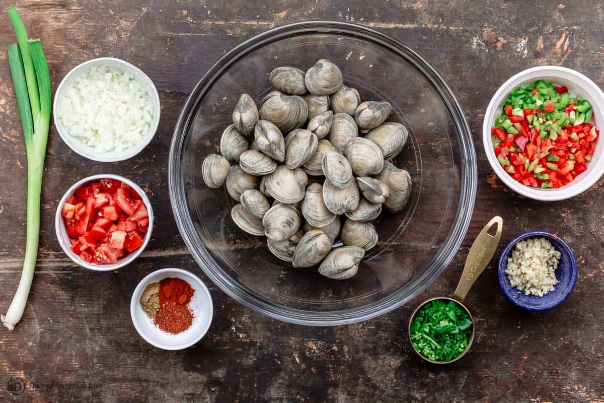 Ingredients for steamed clams recipe. clams, onions, garlic, spices, fresh herbs