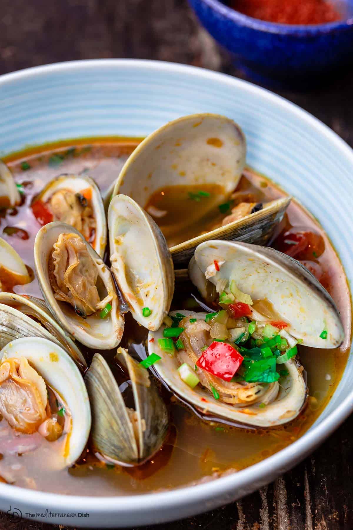 Steamed clams with broth in a serving bowl