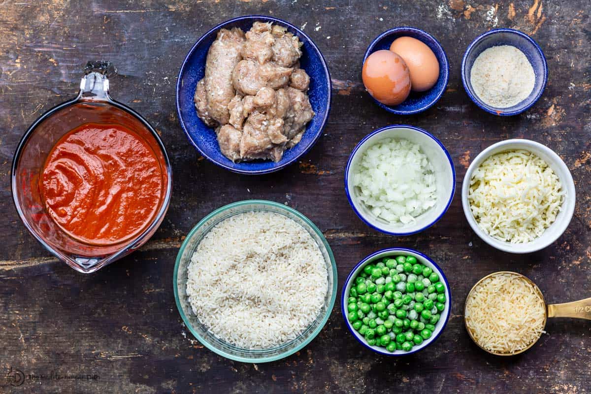 casserole ingredients including rice, sausage, peas, cheese, eggs, marinara sauce