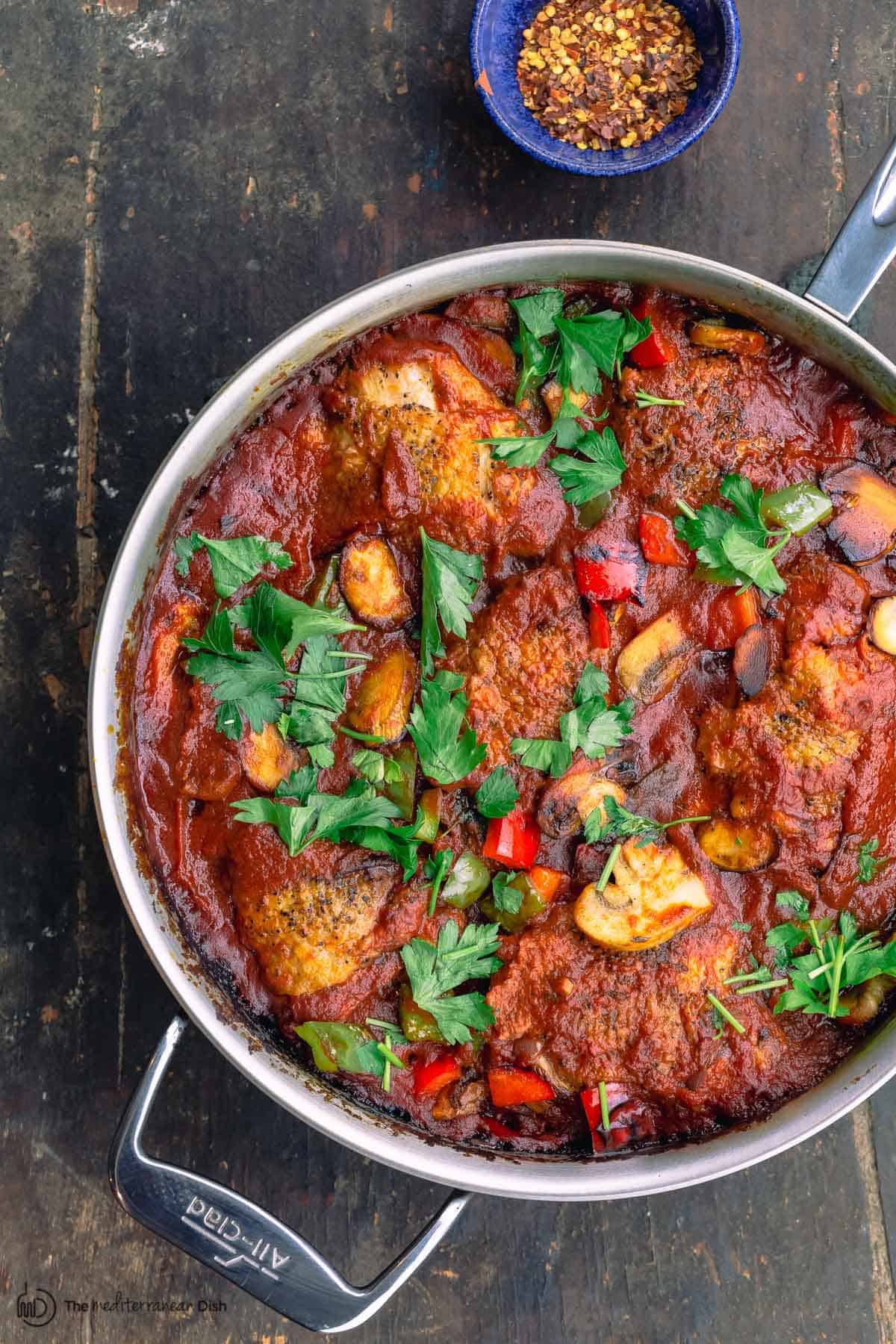 cacciatore with a side of red pepper flakes in a bowl 