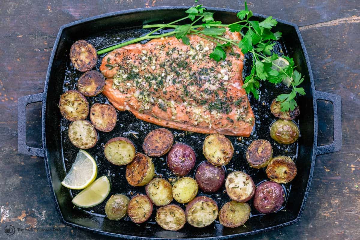 Slow roasted salmon and potatoes with parsley and slices of lemon