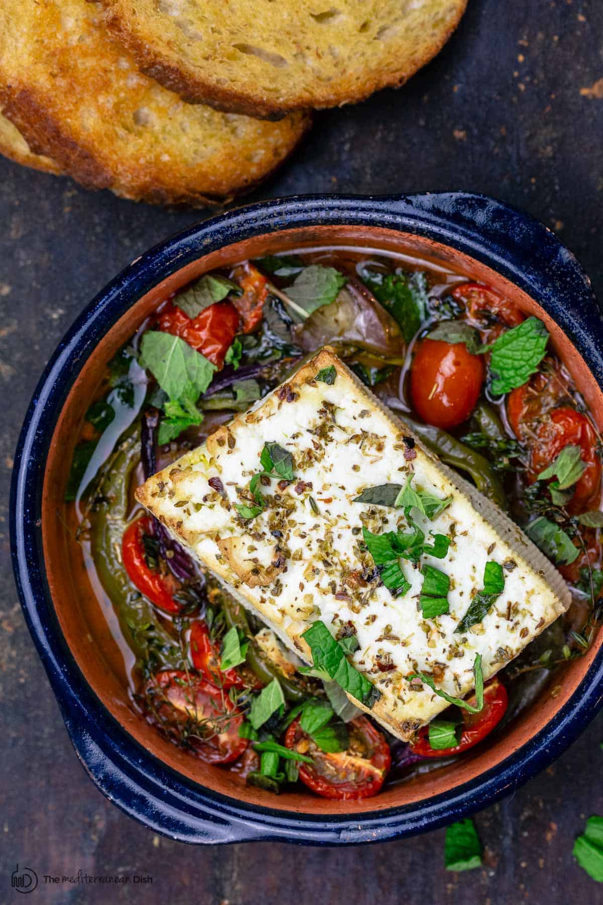 Baked feta served with a side of toasted bread