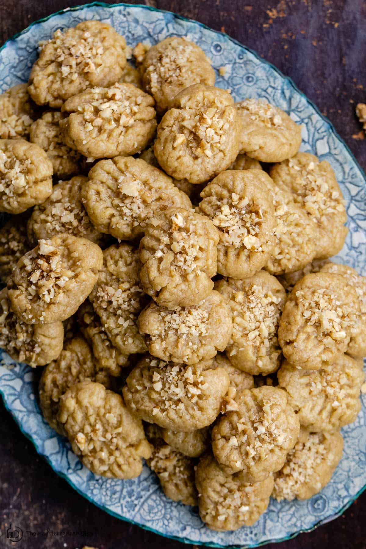 A stack of melomakarona cookies with walnuts on a platter on a platter 