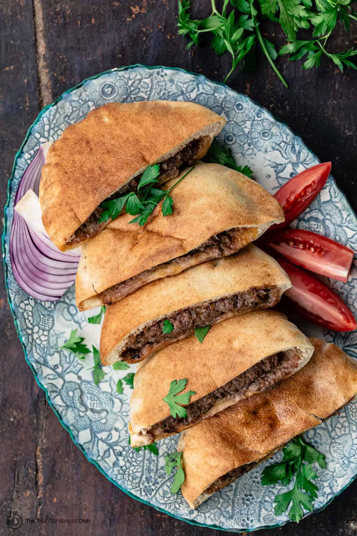 Hawawashi served with sliced tomatoes and red onions