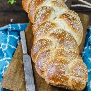 Challah bread on a cutting board with a knife