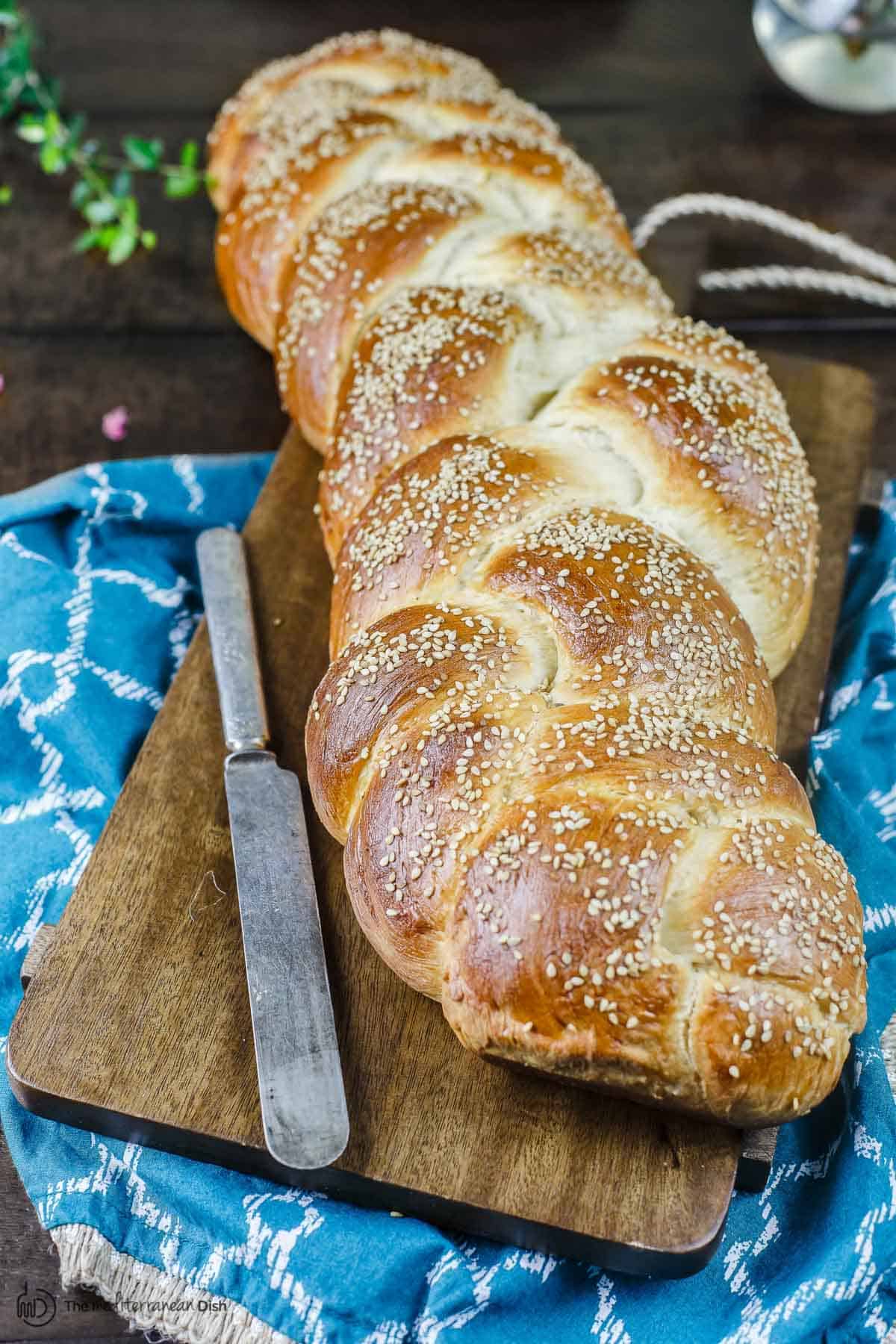 Challah bread on a cutting board with a knife
