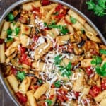 pasta alla norma in big pan with a side of crushed pepper flakes