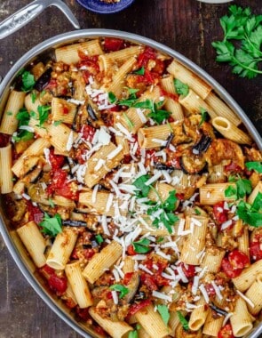 pasta alla norma in big pan with a side of crushed pepper flakes