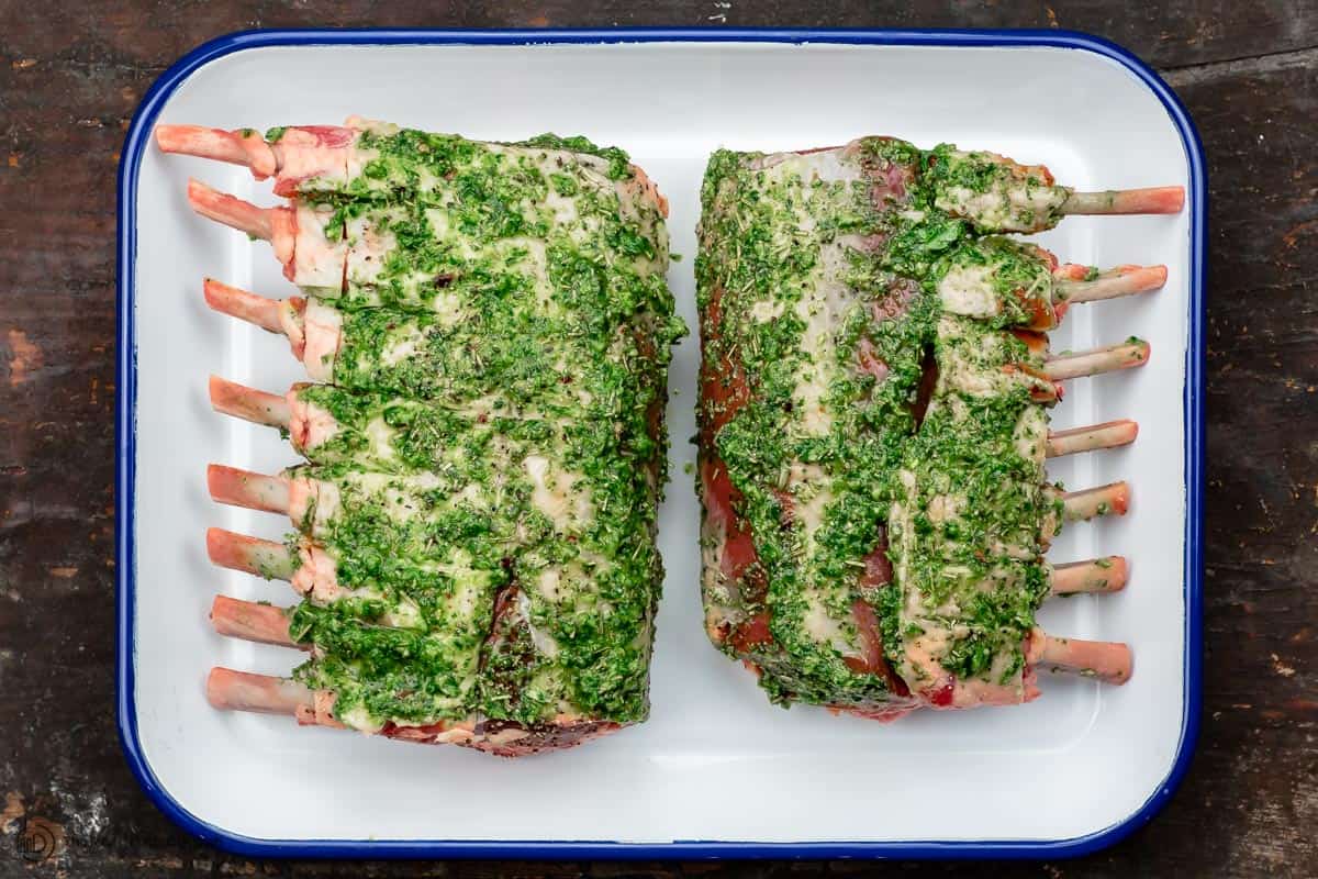 Rack of lamb with garlic and herb marinade covering it on both sides