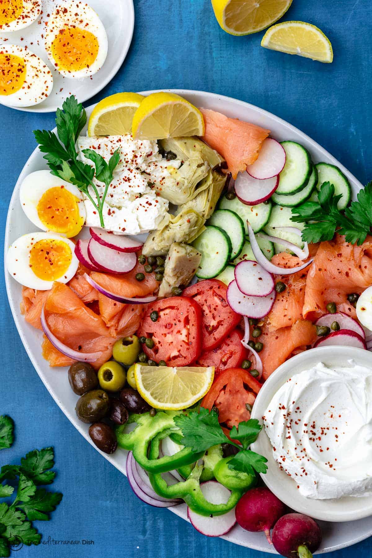 salmon platter with a side of easy boiled eggs and lemon wedges