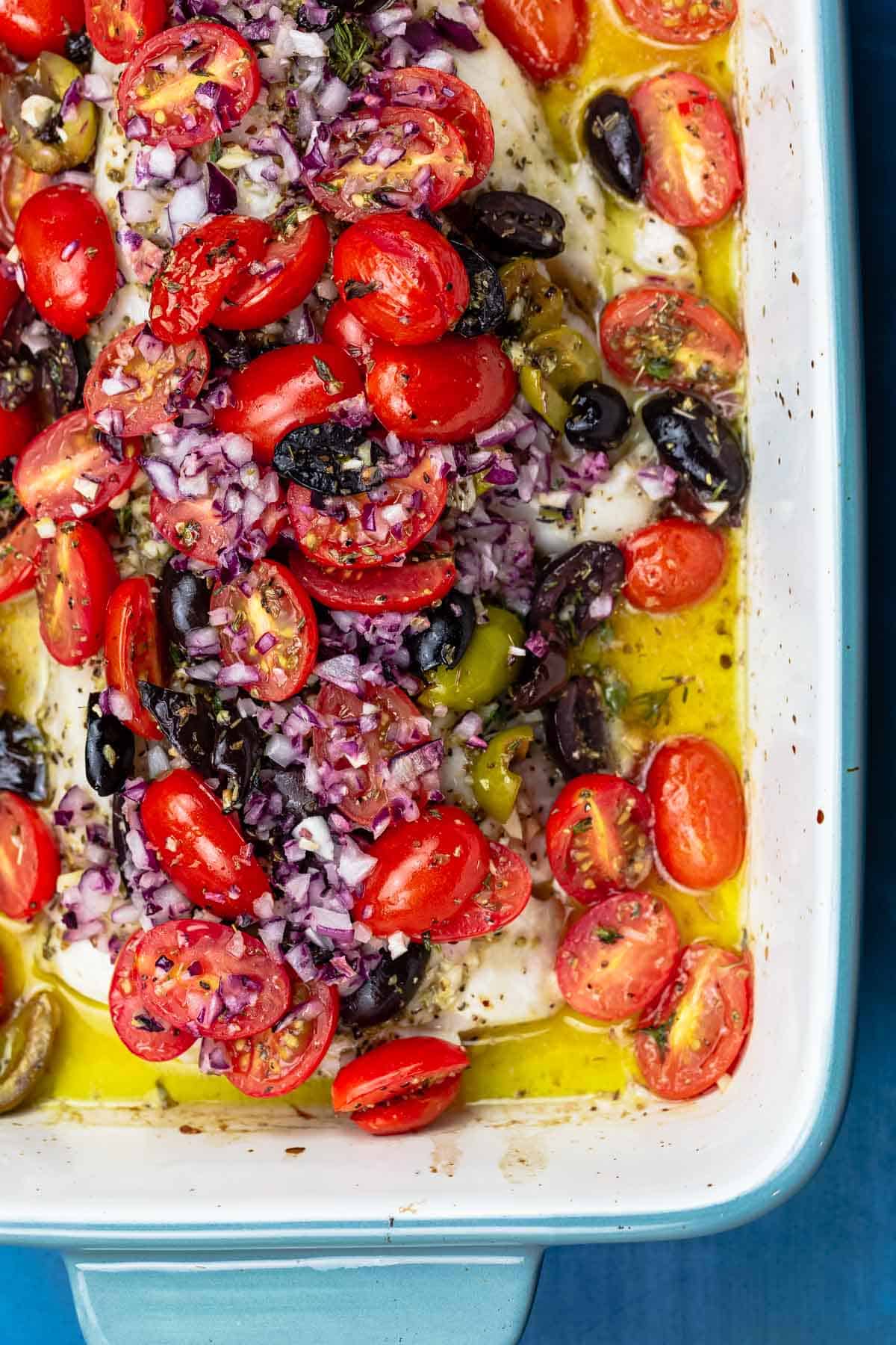 White fish topped with tomatoes and olives