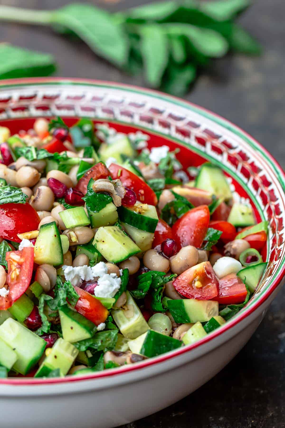 bowl of black eyed pea salad with garnish of fresh mint to the side