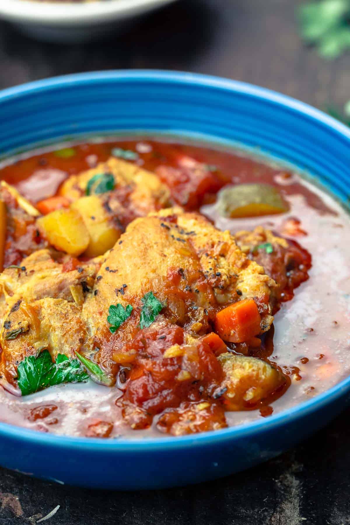 Mediterranean-style chicken stew served in a blue bowl