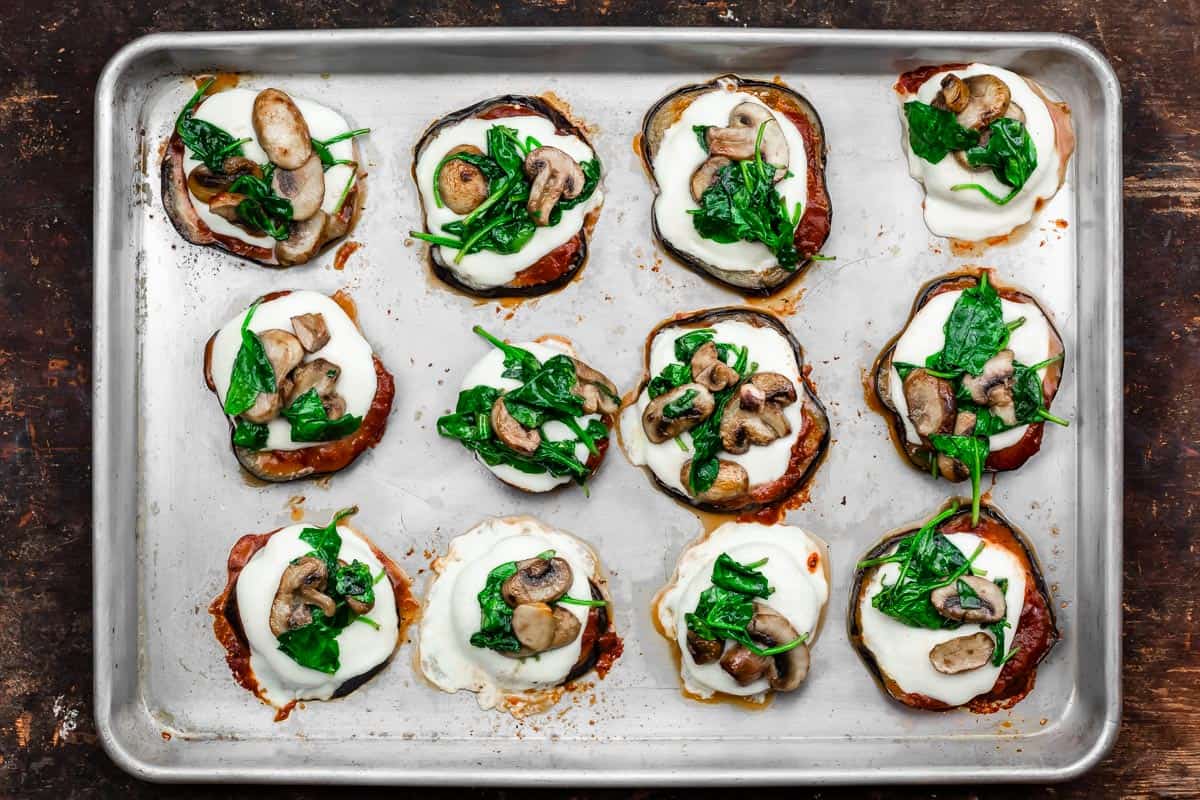 eggplant pizza bites with mushrooms and spinach added on top
