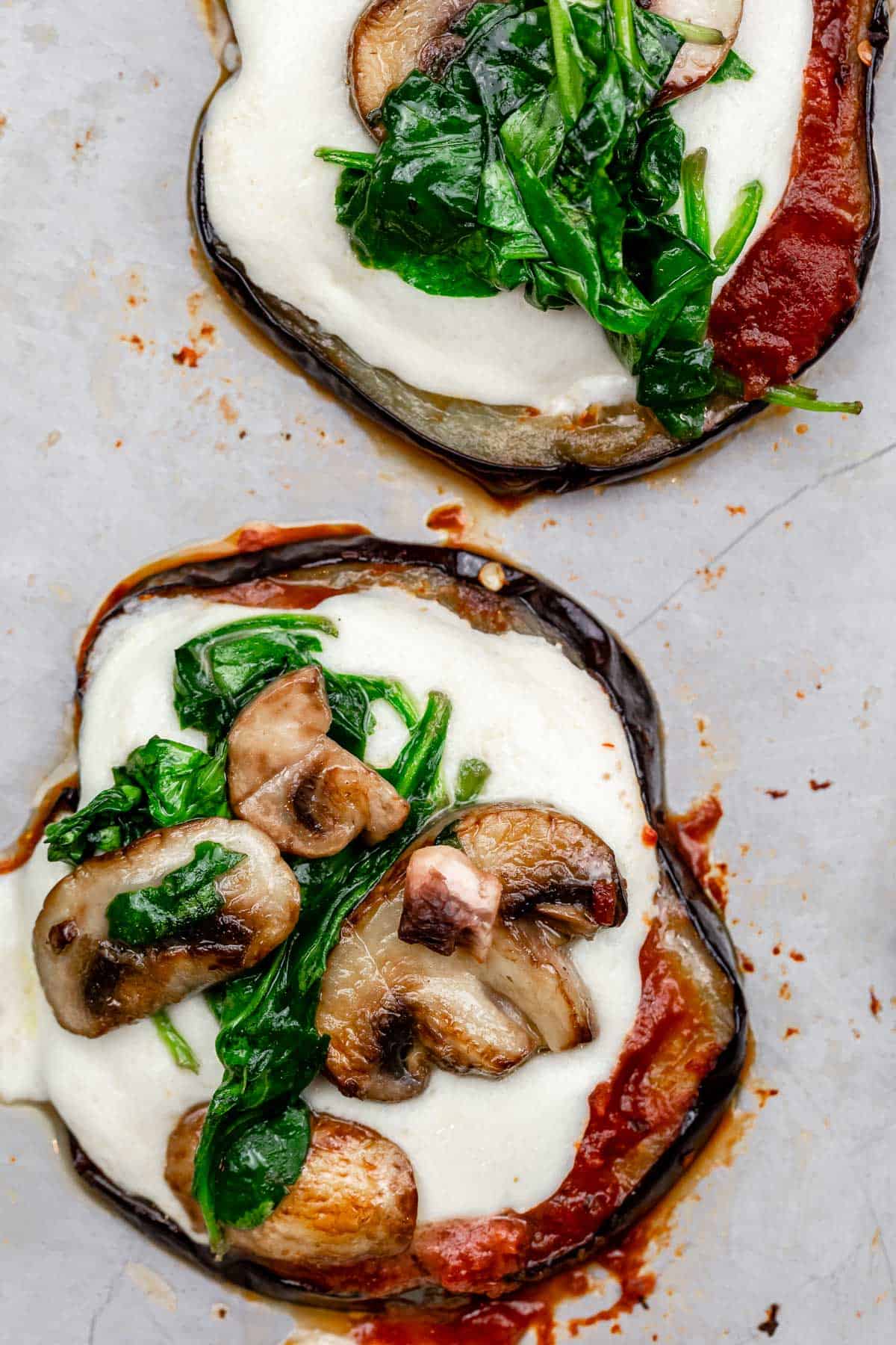 eggplant pizza bites topped with mushrooms and spinach.