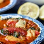 Bowls of Mediterranean Fish Soup with Lemon Wedges to the Side