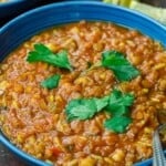 harira served in a bowl, garnished with cilantro with lemon wedges to the side