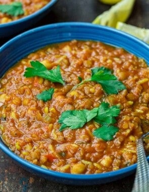 harira served in a bowl, garnished with cilantro with lemon wedges to the side