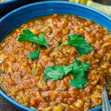 harira served in a bowl, garnished with cilantro with lemon wedges to the side