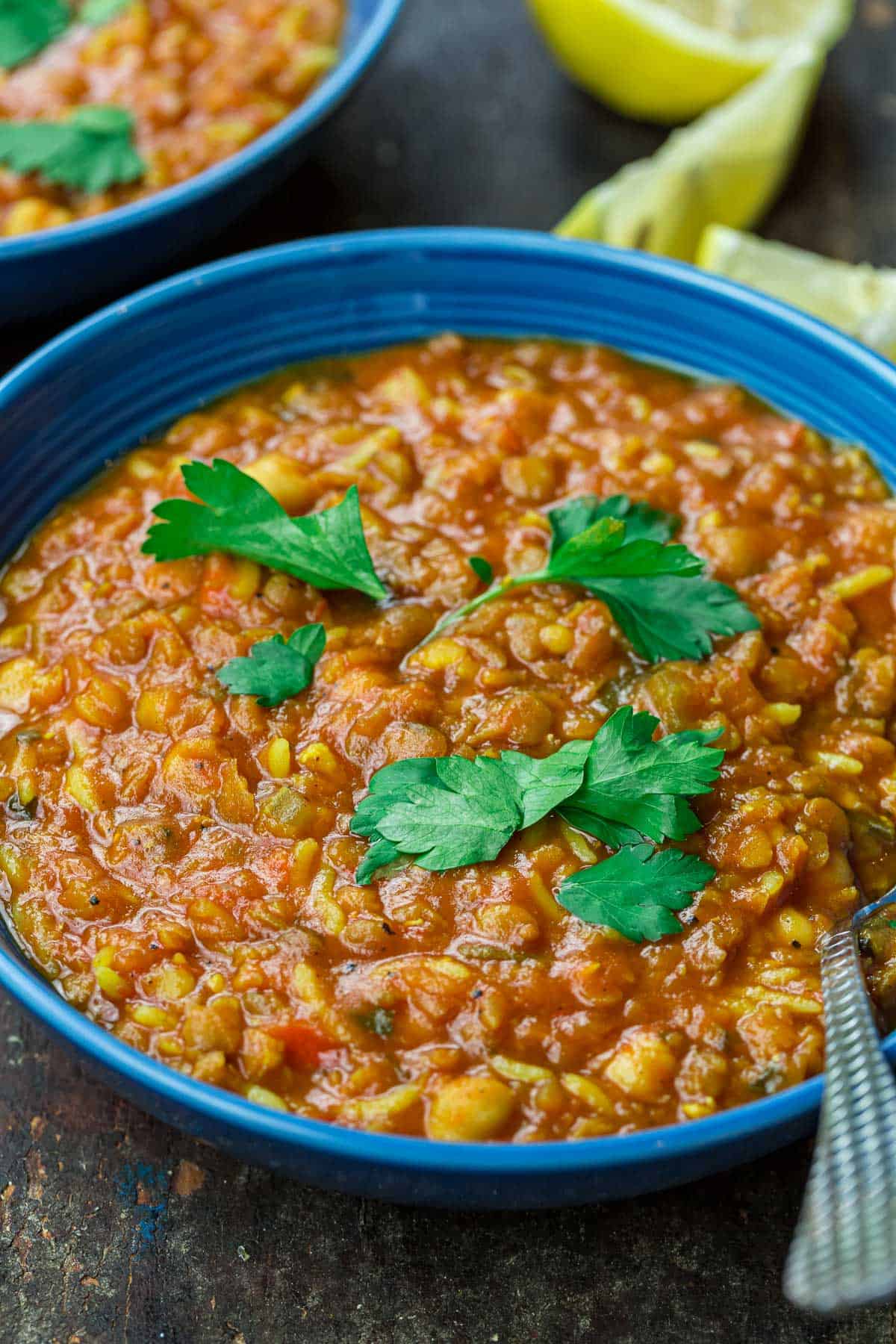 harira served in a bowl, garnished with cilantro with lemon wedges to the side