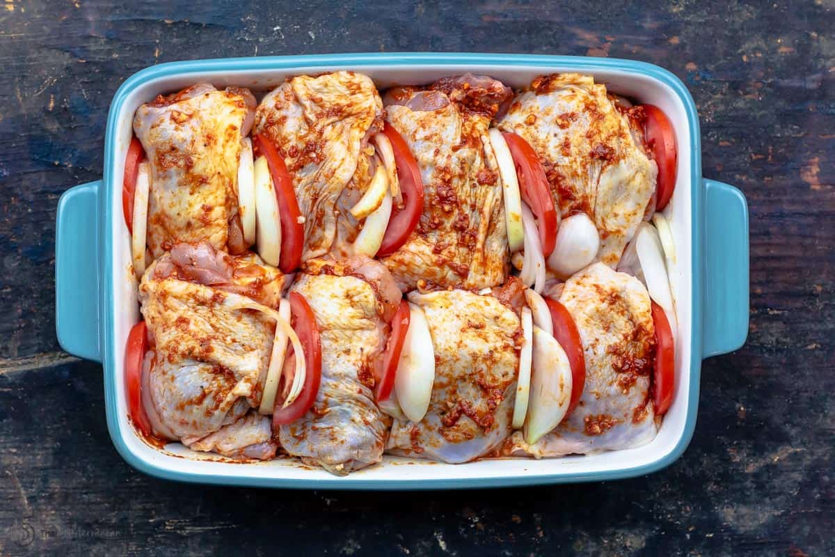 Raw chicken thighs placed in a baking dish