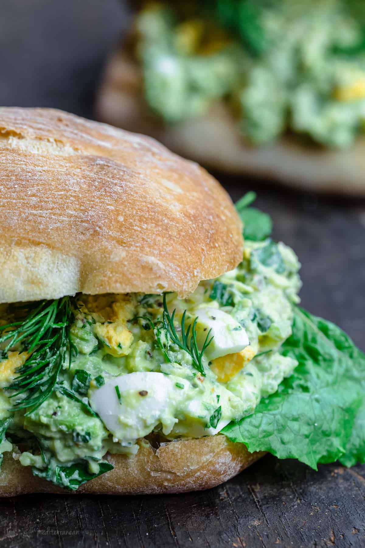 Avocado egg salad sandwich with lettuce and dill
