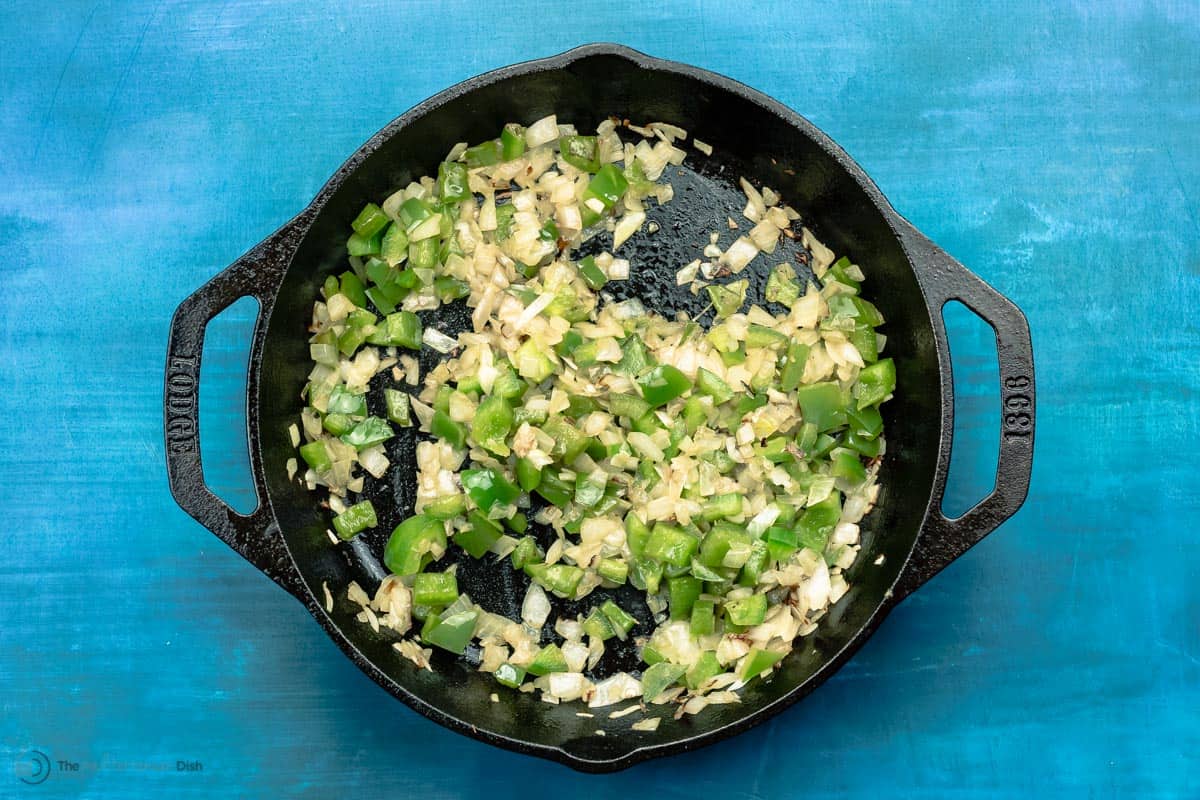 Green peppers, chopped garlic and onions sauteed in cast iron skillet