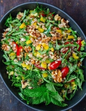 farro salad with arugula in a bowl mixed with walnuts and fresh vegetables