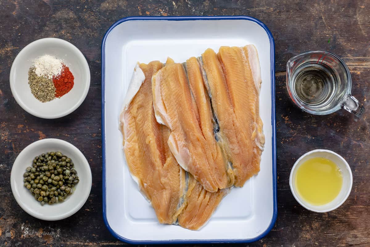 The ingredients needed to make fish piccata measured in glass dishes