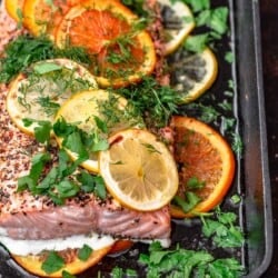 Salmon in cast iron skillet with slices of oranges