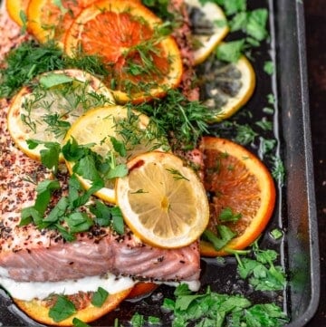 Salmon in cast iron skillet with slices of oranges