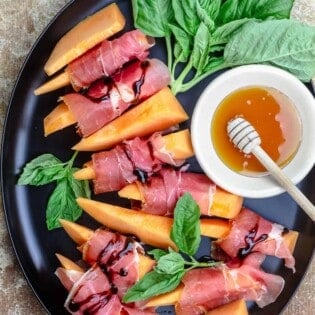 Prosciutto and melon served on a large plate