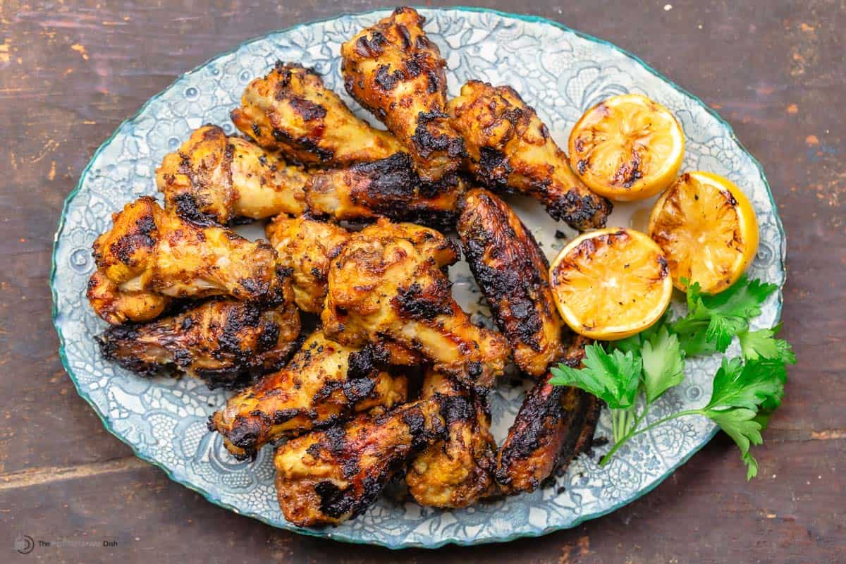 A blue plate with grilled chicken wings