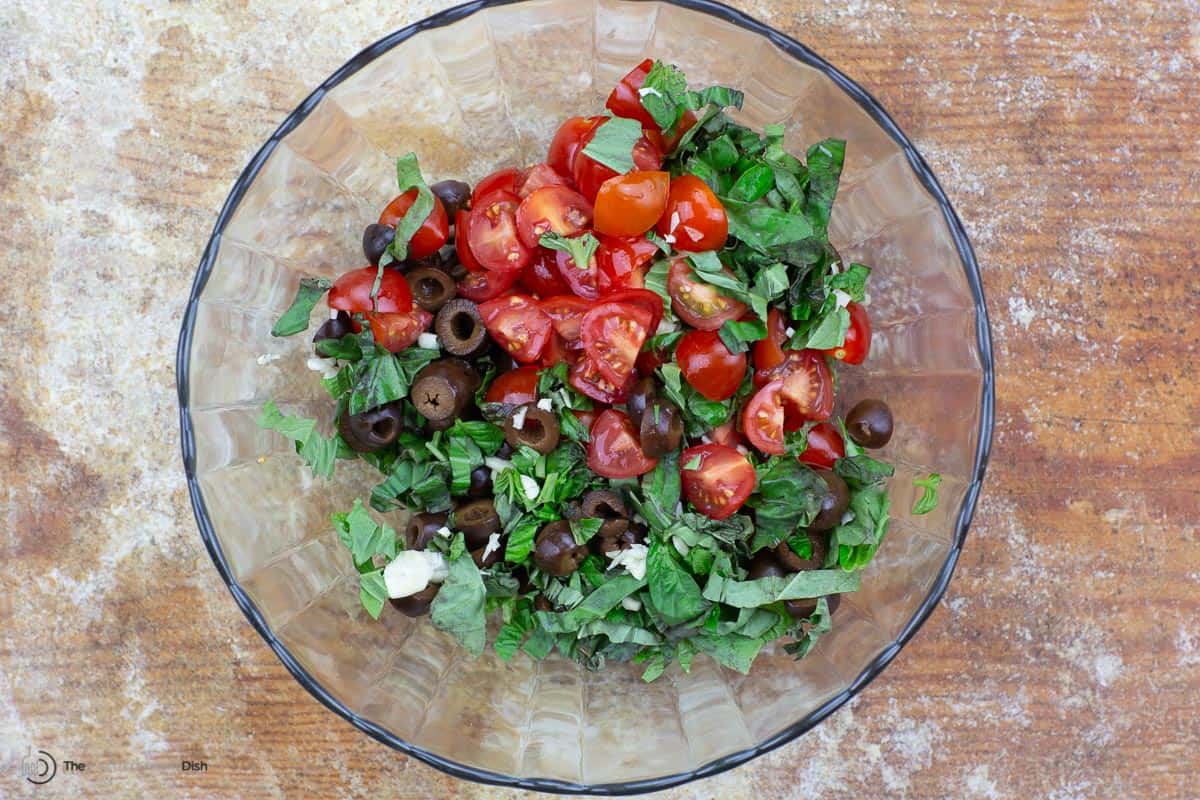 olives, tomatoes, basil, and garlic tossed in a bowl