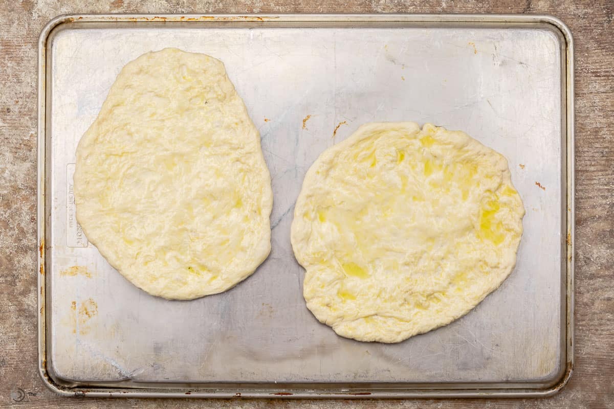Raw pizza dough crust in baking sheet