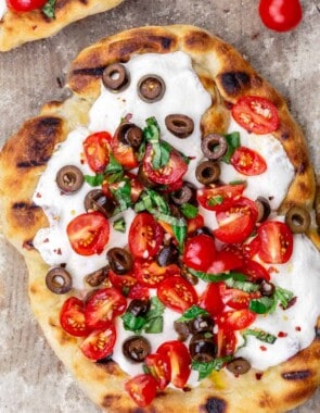 Grilled pizza with tomatoes, basil and olives