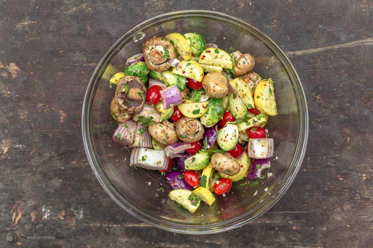 Summer veggies marinating in a glass mixing bowl