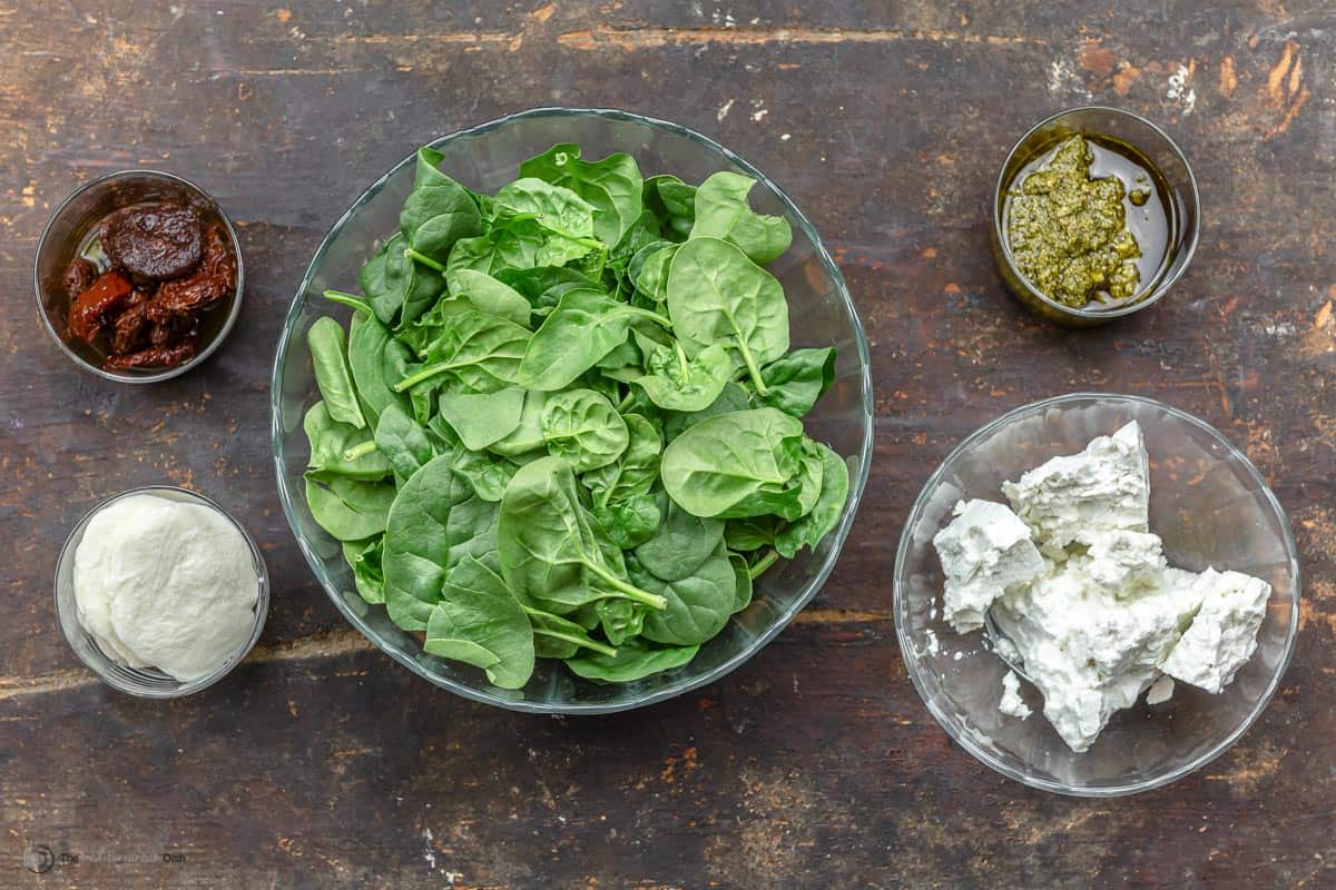 ingredients. Mozzarella, feta, spinach, sun-dried tomatoes, basil pesto