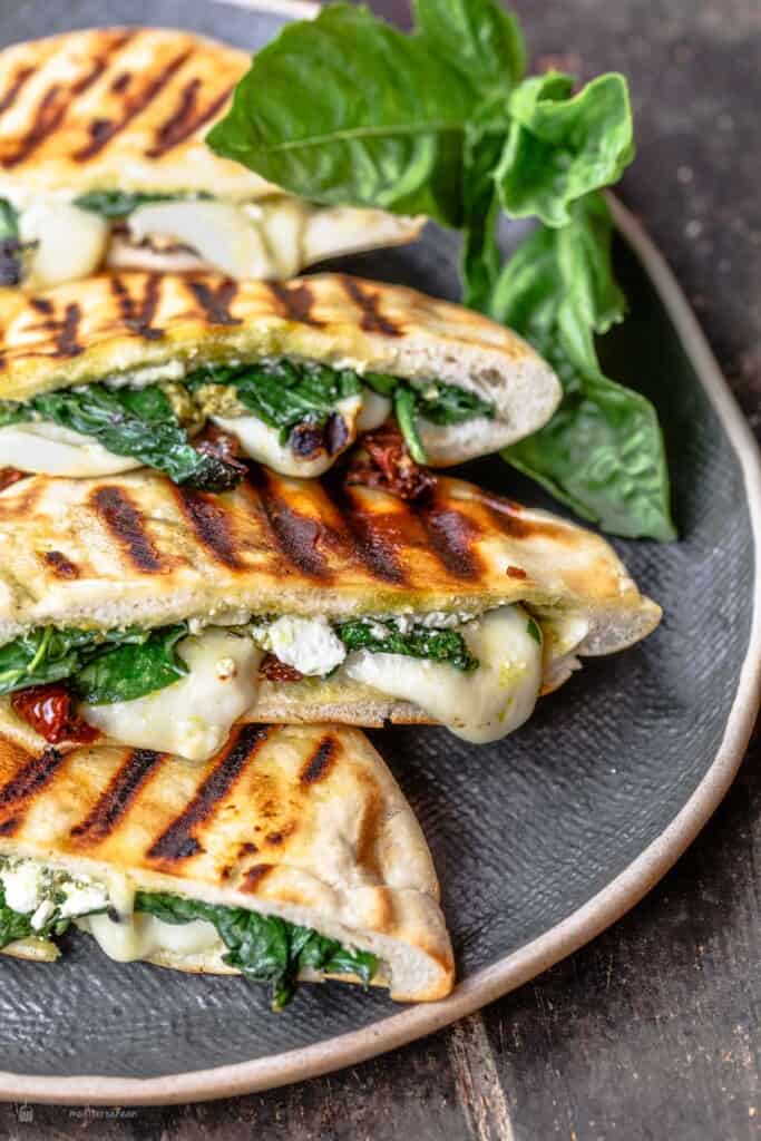 pita grilled cheese sandwiches assembled on black platter with basil garnish