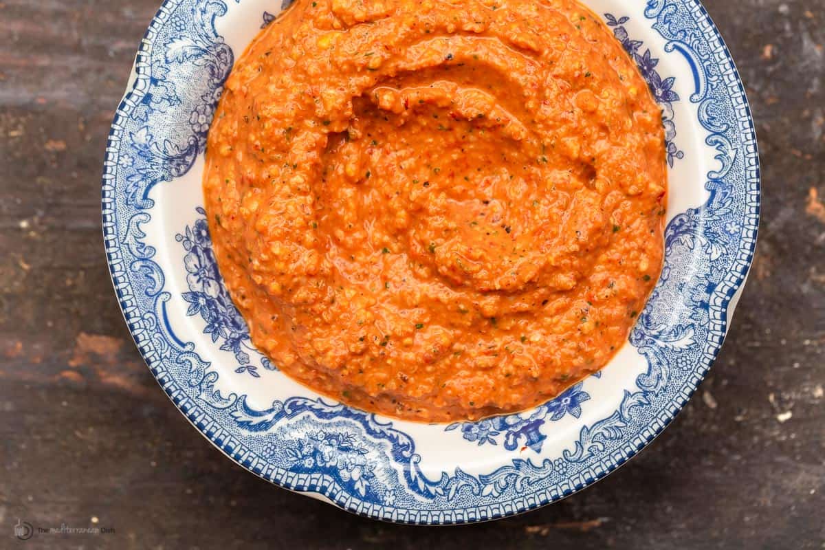 A blue and white bowl of Spanish red pepper sauce