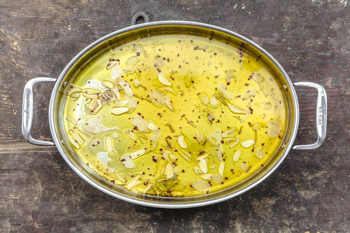 A pan with olive oil, garlic and pasta water
