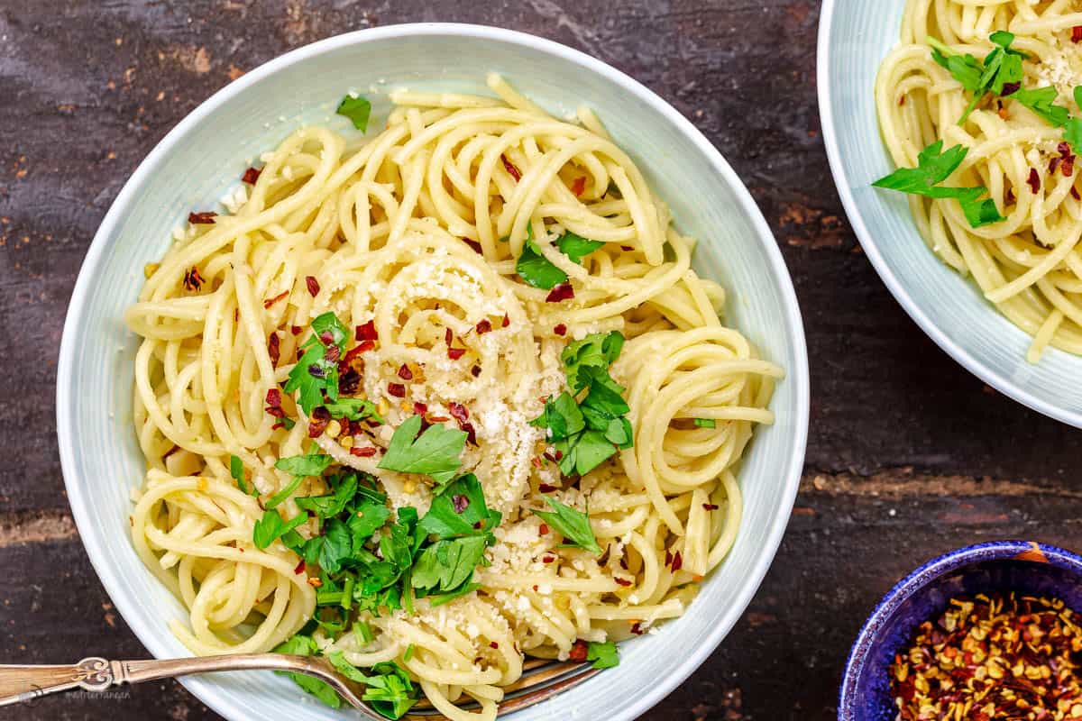 A white bowl of spaghetti aglio e olio