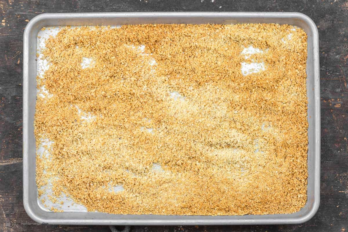 Breadcrumbs on a baking dish to be toasted.